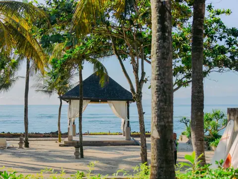 Palm trees and a pavilion on a Bali beach