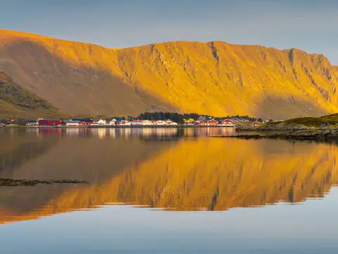 Mountain in evening light above still water in Lofoten